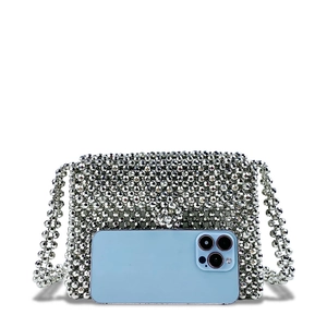 Macro detail of handmade silver metallic beaded crossbody bag next to a smartphone