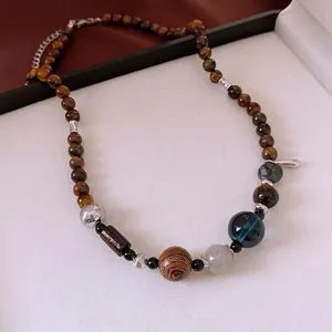 Tiger eye stone and wooden beaded necklace with silver metal accents on a jewelry tray