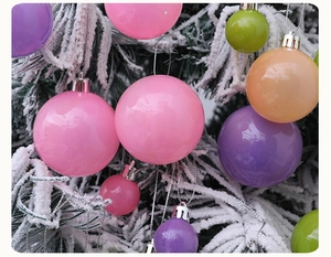 Boules de Noël macaron colorées sur des branches de pin enneigées pour décoration