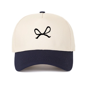Close-up of bow embroidery on two-tone baseball cap with fine cotton twill texture