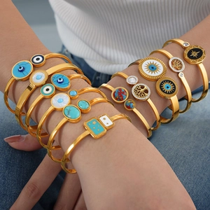 Bohemian style stackable gold bangles with turquoise and shell inlays on female model