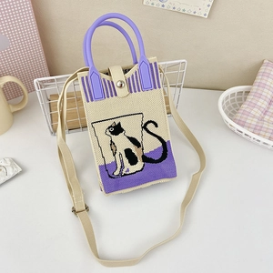 Detail of knitted shoulder bag with cute black cat pattern and purple handle
