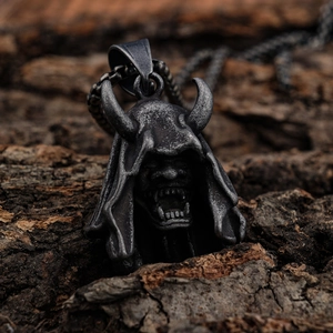 Gothic demon Hannya mask pendant in antique silver stainless steel on bark background