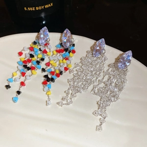 Macro shot of rhombus crystal tassel earrings with colorful and clear beads on white tray