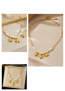 Detail of gold-plated starfish pendants and white pearls on an elegant chain necklace