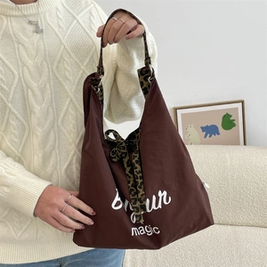Detail of brown canvas tote bag with Bonjour print and leopard pattern lining