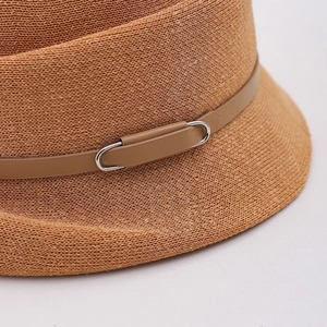 Détail du chapeau de paille tressé avec sangle en cuir marron et boucle métallique