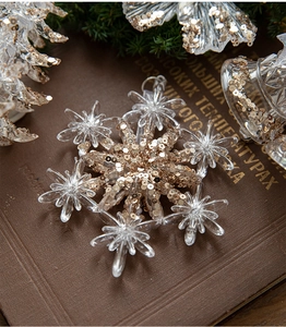 Dettaglio di fiocchi di neve in acrilico con paillettes dorate su un libro antico