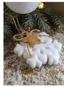 Close-up of white snowflake ornament with cork star and pine cone on rustic wood surface