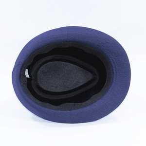 Internal detail of a dark purple wool fedora hat featuring sweatband and fabric tag
