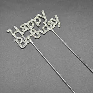 Detailed view of silver metal Happy Birthday cake topper with rhinestones