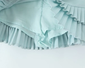 Detailed view of striped mini skirt with built-in safety shorts in mint green fabric
