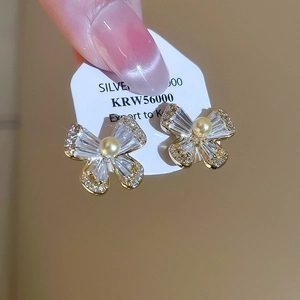 Detail of gold plated butterfly earrings with sparkling cubic zirconia and pearl