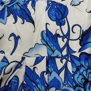 Dettaglio di abito a fiori blu con cerniera invisibile e vita con pieghettatura