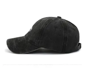 Detailed side view of washed black cotton baseball cap with adjustable metal buckle strap