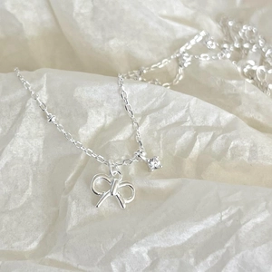 Elegant 925 sterling silver bow necklace with zircon pendant on a white background