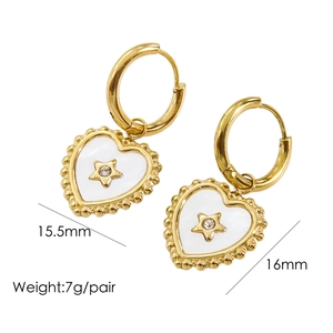 Detail view of 14K gold heart earrings with white inlay and star motif accents