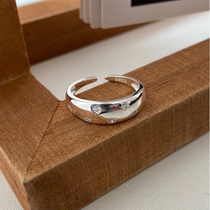 Detailed close-up of S925 sterling silver star ring with micro-set zircon on wood