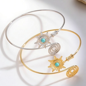 Detail of vintage turquoise arm cuffs with sunburst pattern and spiral adjustable design