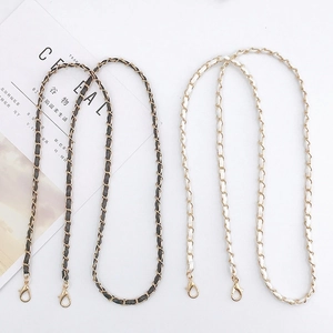 Detail of black and white leather interwoven chain straps with gold lobster clasps