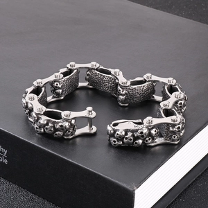 Detailed macro of vintage stainless steel punk skull links on a chunky bike chain bracelet