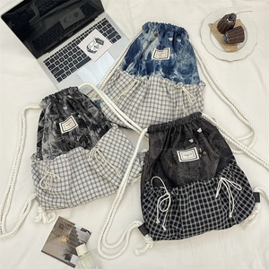 Detailed flat lay of plaid drawstring backpacks with thick rope straps in three colors