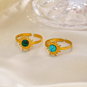 Golden sunburst open rings featuring turquoise and malachite stones on silk fabric