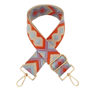 Close-up of diamond jacquard woven strap with golden metal carabiners for bags