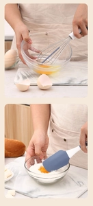 Silicone whisk and spatula mixing eggs and flour in glass bowls on marble countertop
