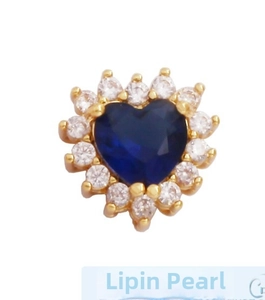 Macro shot of heart-shaped blue gemstone pendant with white zircon halo in gold plating