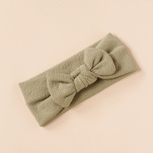 Detailed view of an olive green textured knit baby headband with a soft bow decoration
