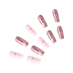 Detail of glossy pink press-on nails with heart embossing and silver glitter finish