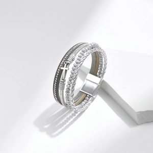 Detail showing the multilayer braided bracelet with a cross pendant and magnetic clasp