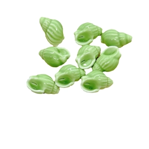 Multiple light green conch-shaped ceramic beads with a glossy finish on white background