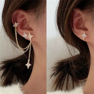 Detail of star-shaped tassel earring with rhinestones and layered gold chains