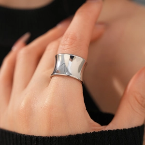 Close-up of minimalist silver wide band ring with high-polished mirror finish on finger