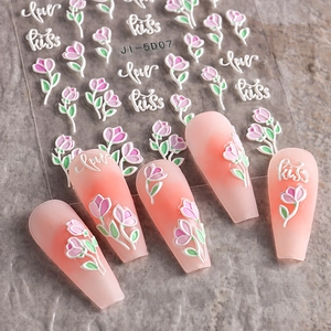 Macro shot of 3D embossed nail art stickers with pink tulips and romantic lettering