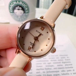 Elegant rose gold quartz watch with beige leather strap for women shown in lifestyle hand setting