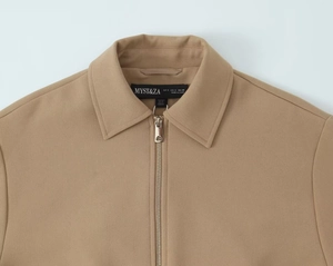 Gros plan détaillé d'une veste à fermeture éclair camel avec col et étiquette de taille