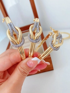 Makroaufnahme goldener Knotarmbänder mit Pavé-Diamanten auf einer Schmuckschatulle