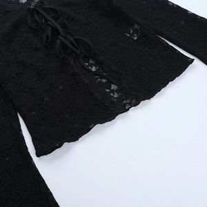 Detail view of black sheer lace top featuring an intricate floral pattern and lace-up front
