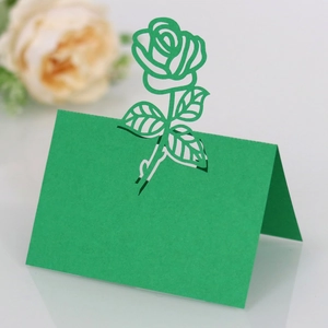 Macro shot of green laser-cut 3D rose place card for weddings with hollow floral detail