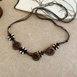 Detail of bohemian waist chain with wooden pendants and woven resin bead accents