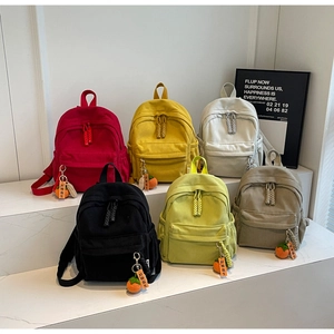 Detail of corduroy mini backpack with double zipper and lucky persimmon charm