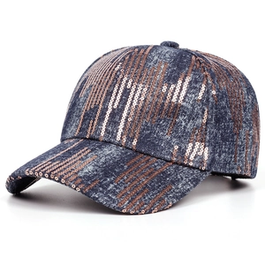 Close-up of a blue denim baseball cap featuring rose gold sequins and washed fabric detail