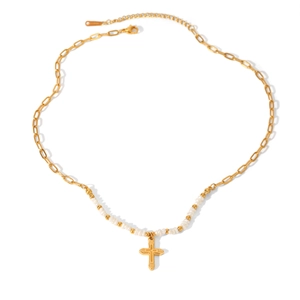 Detailed view of gold cross pendant necklace with white seed beads and metal chain