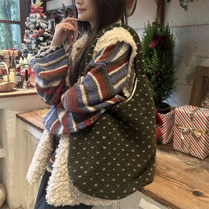 Detail of dark green fuzzy tote bag with heart patterns in a cozy winter setting