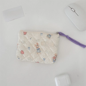 Detailed close-up of a quilted floral mini coin purse with cartoon rabbit pattern