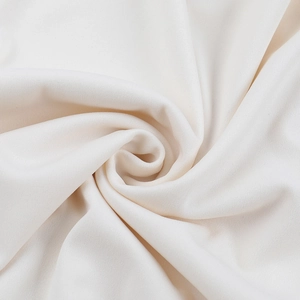 Close-up of white dress fabric showing soft silk texture and fine weaving details