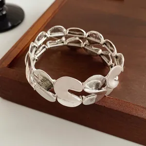 Vintage silver S-shaped textured metal link bracelet on a minimalist wooden display tray